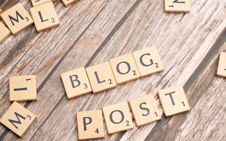 Wooden letter tiles spelling 'Blog Post' on a wooden background, ideal for online media concepts. Carreaux de lettres en bois épelant « Blog Post » sur un fond en bois, idéal pour les concepts de médias en ligne.