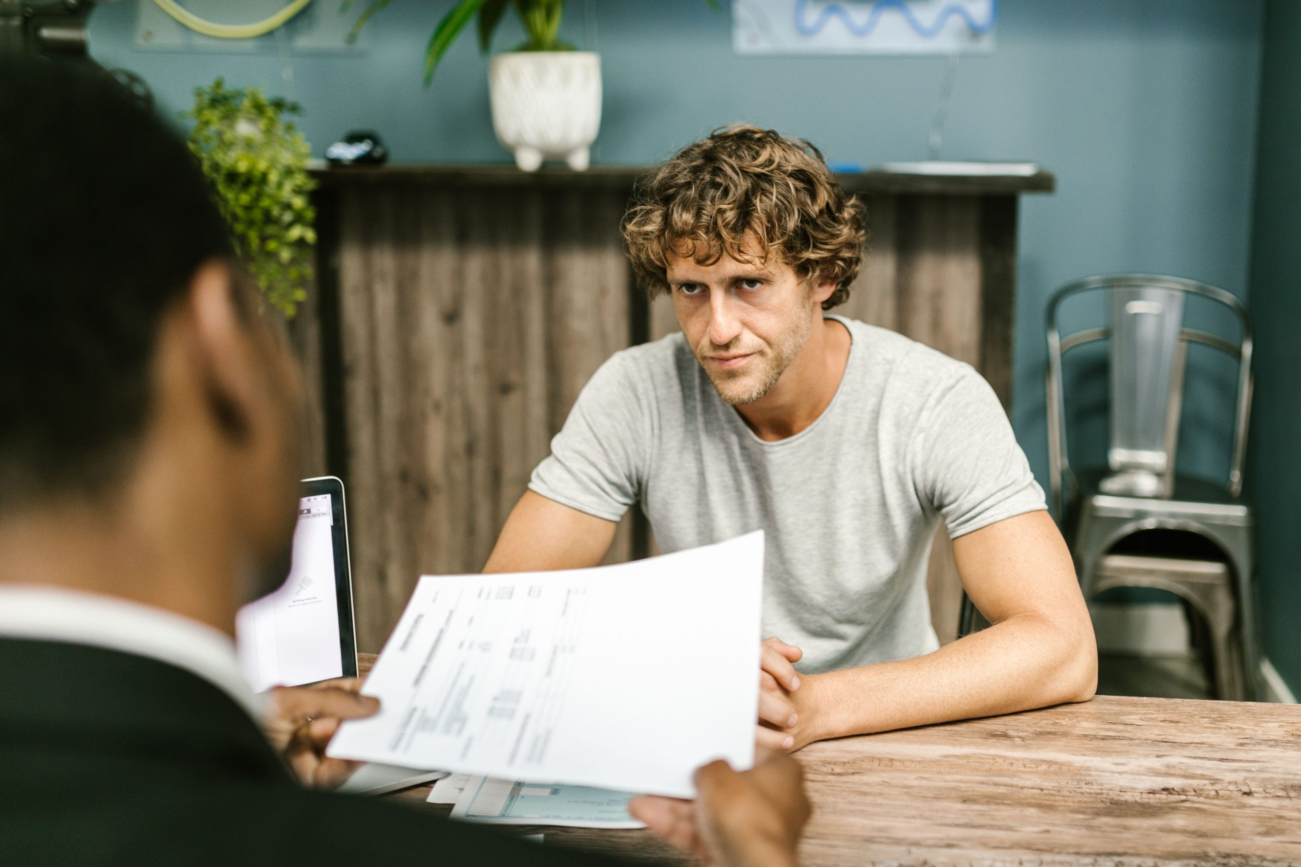 Deux hommes discutent documents réunion professionnelle
