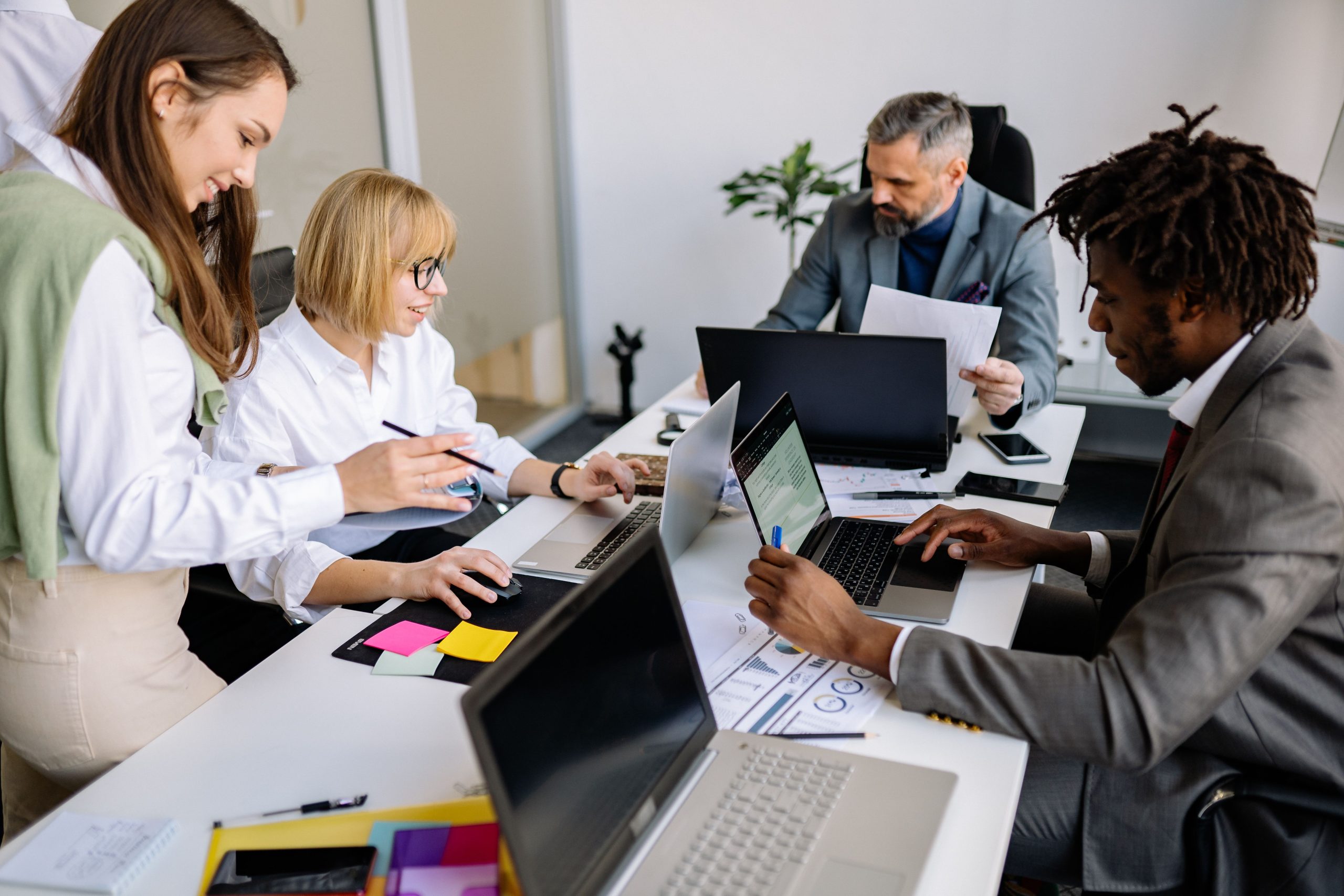Équipe diverse collabore sur ordinateurs portables