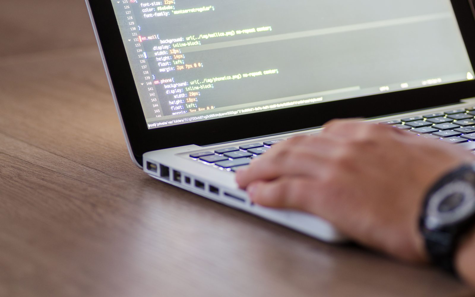 Développeur codant sur laptop avec code HTML affiché
