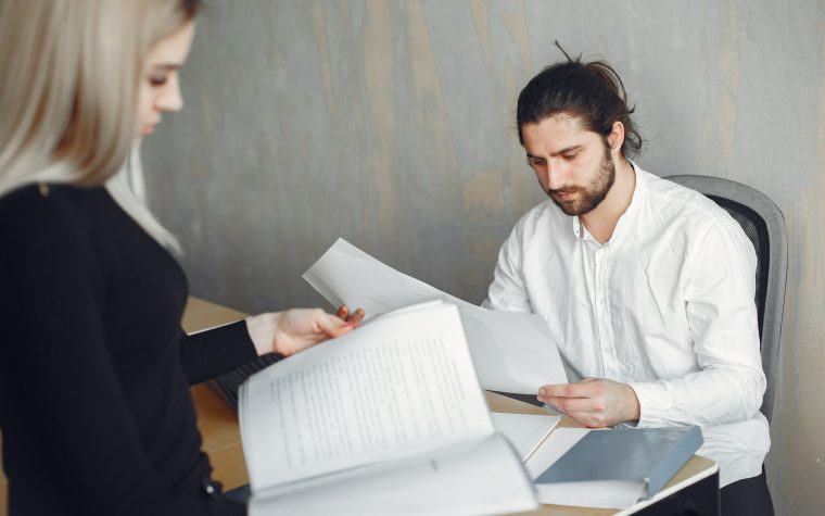Deux professionnels examinent documents importants bureau