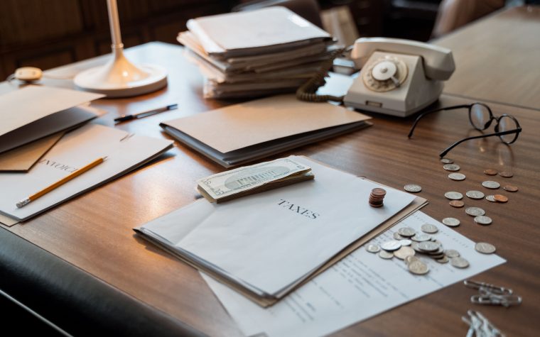Bureau avec documents fiscaux, pièces et verres