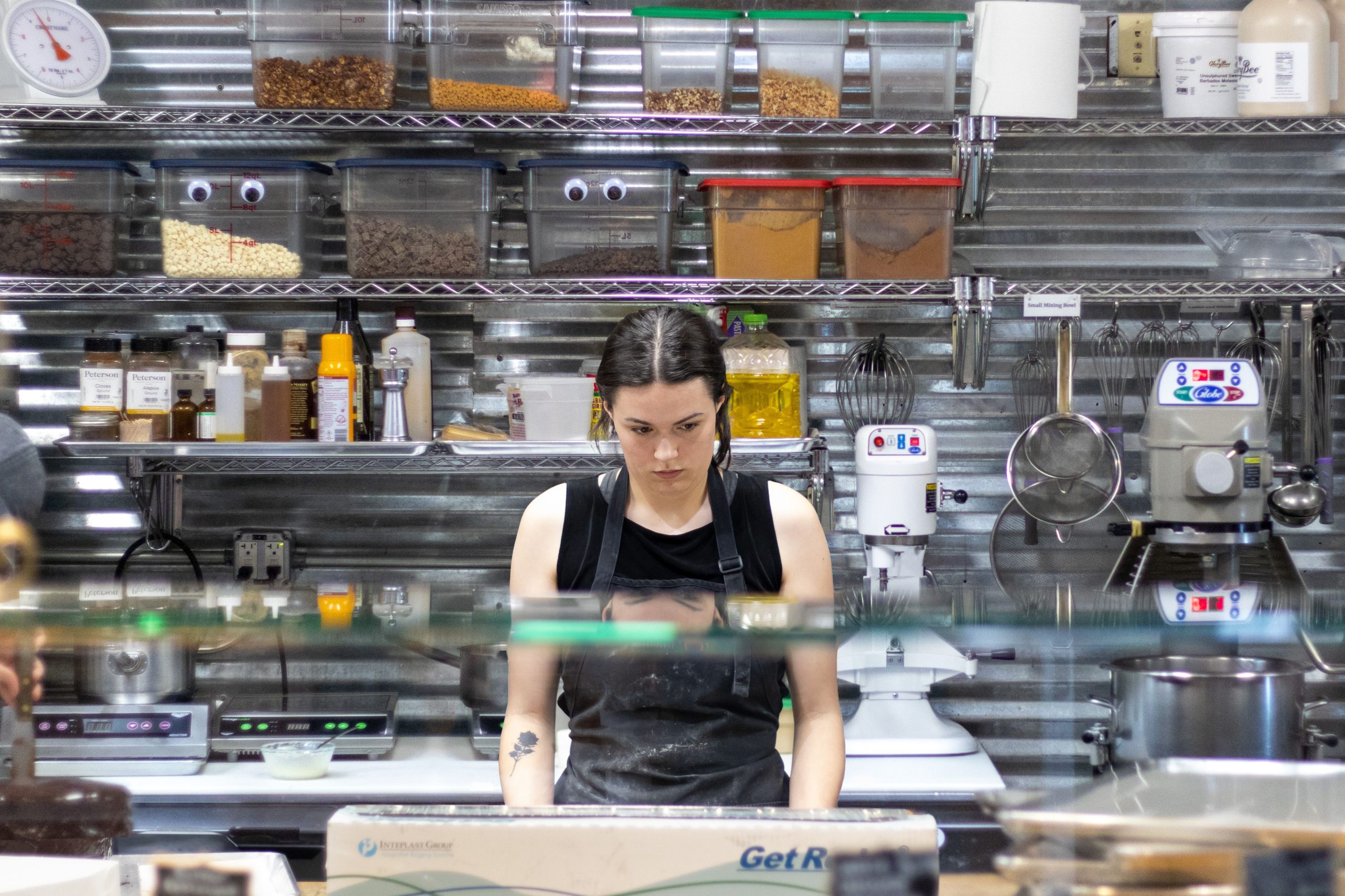 Femme travaillant en cuisine avec épices et équipements