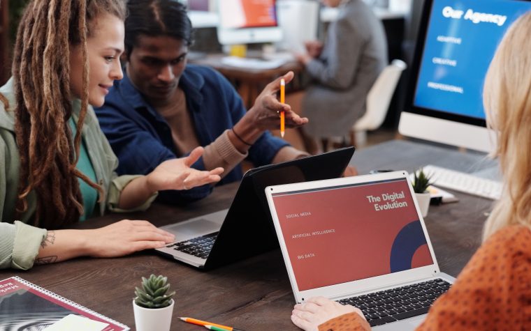 Équipe diverse collaborant sur ordinateurs portables en bureau moderne
