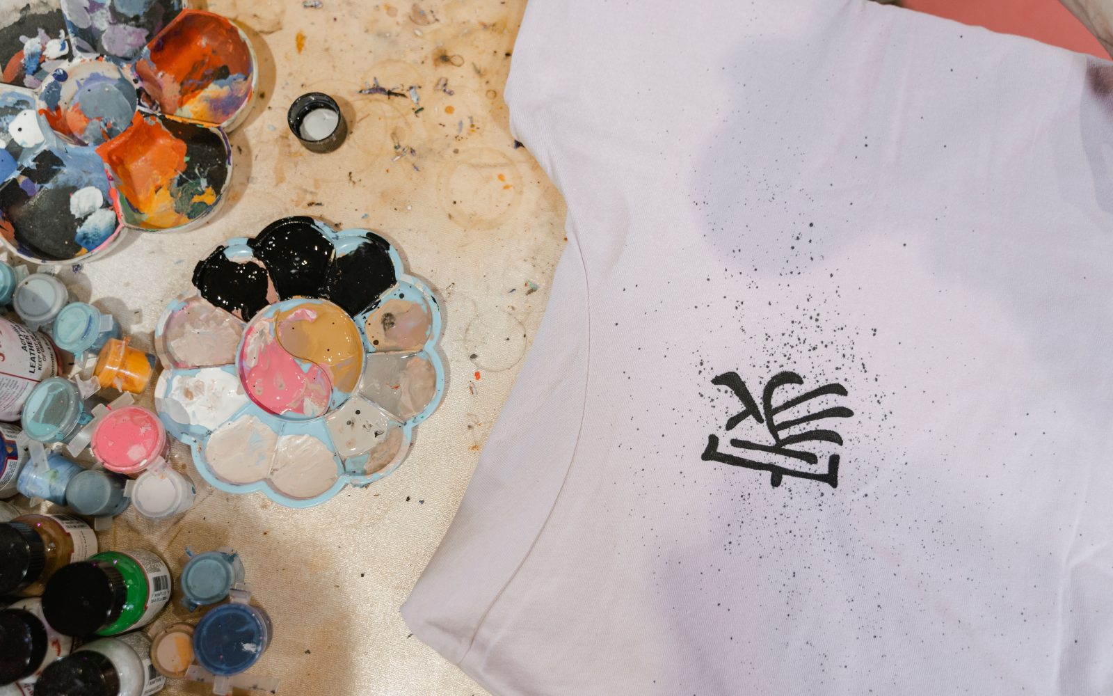 T-shirt artistique entouré de fournitures colorées