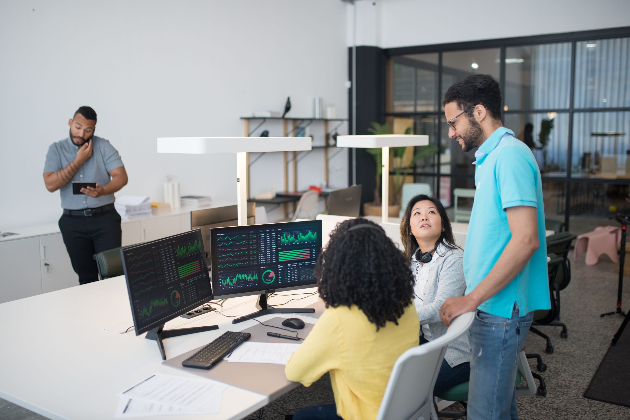Employés collaborant sur données financières à espace de travail moderne