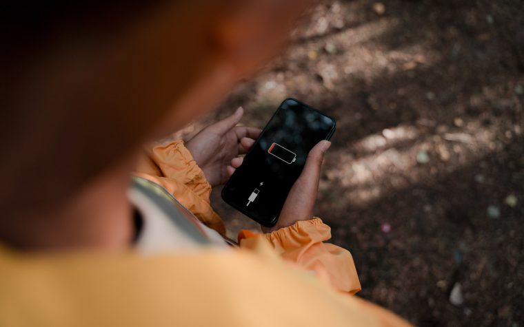 Adolescent tenant smartphone batterie faible forêt