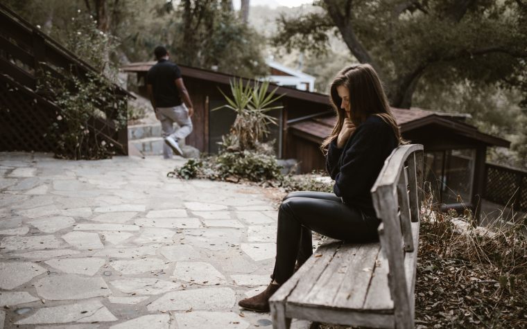 Femme pensive seule sur un banc après rupture