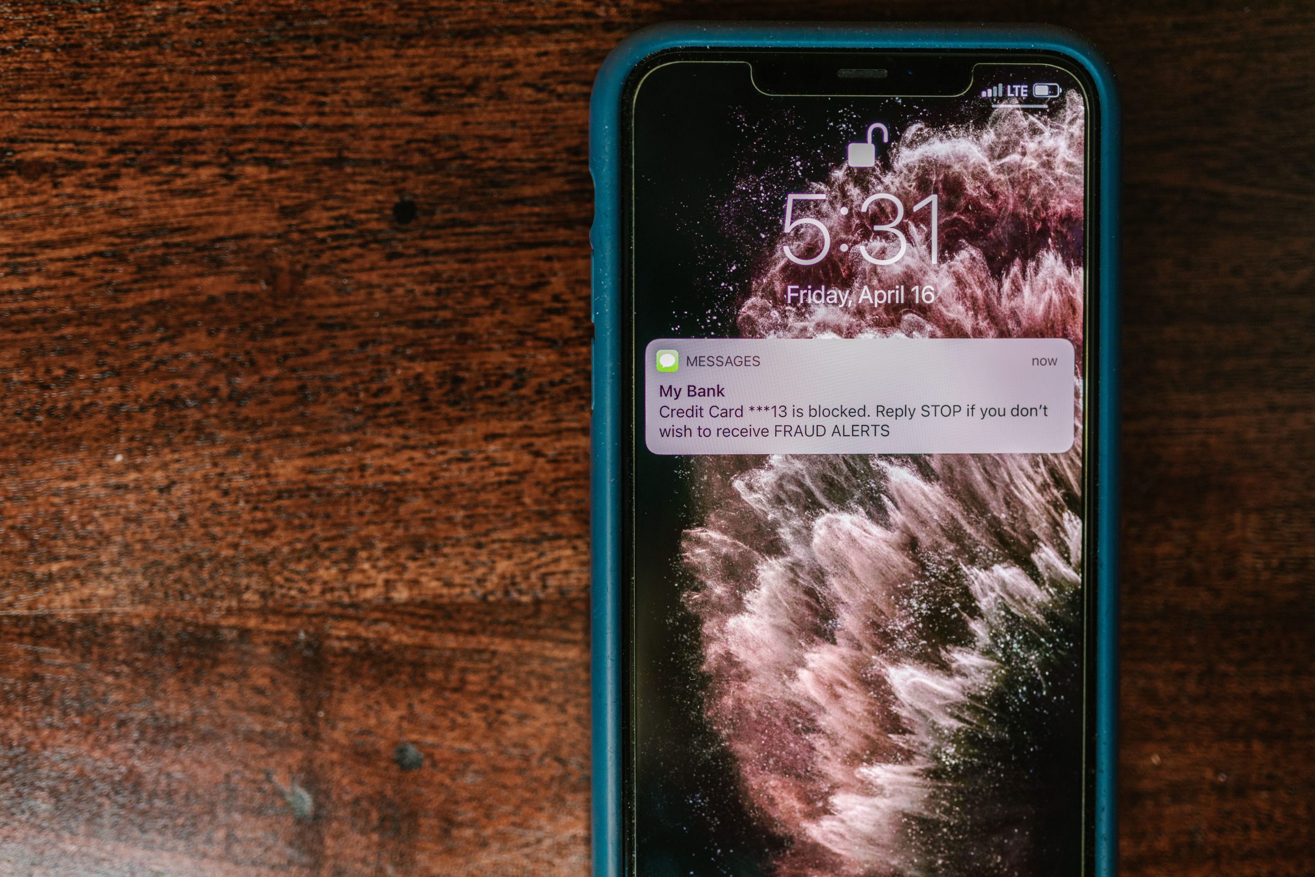 Smartphone affichant message alerte fraude sur bois
