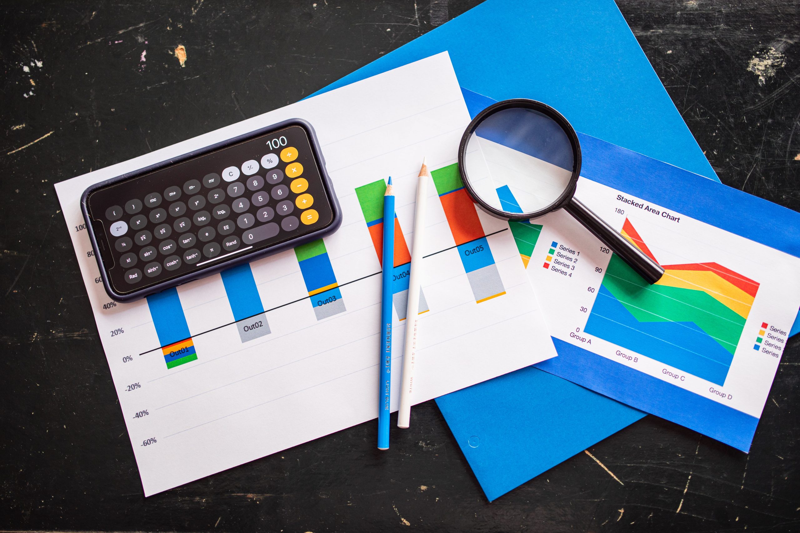 Tableaux financiers avec calculatrice, loupe et crayons