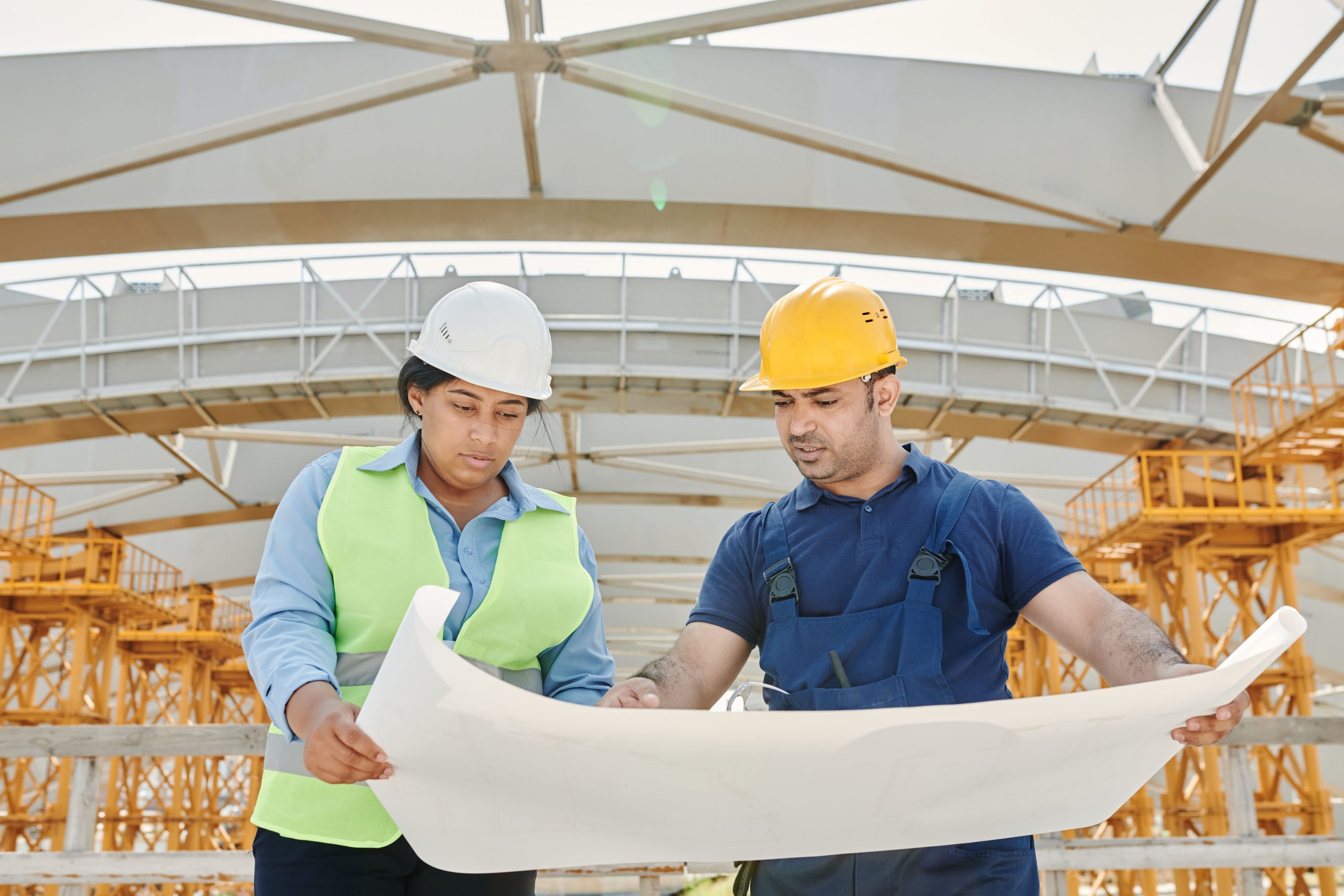 Ingénieurs discutant blueprints sur chantier