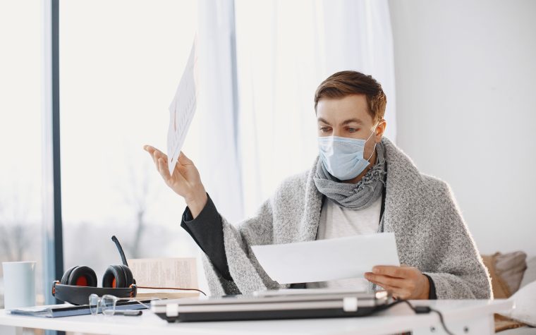 Homme malade travaillant à domicile sous couverture