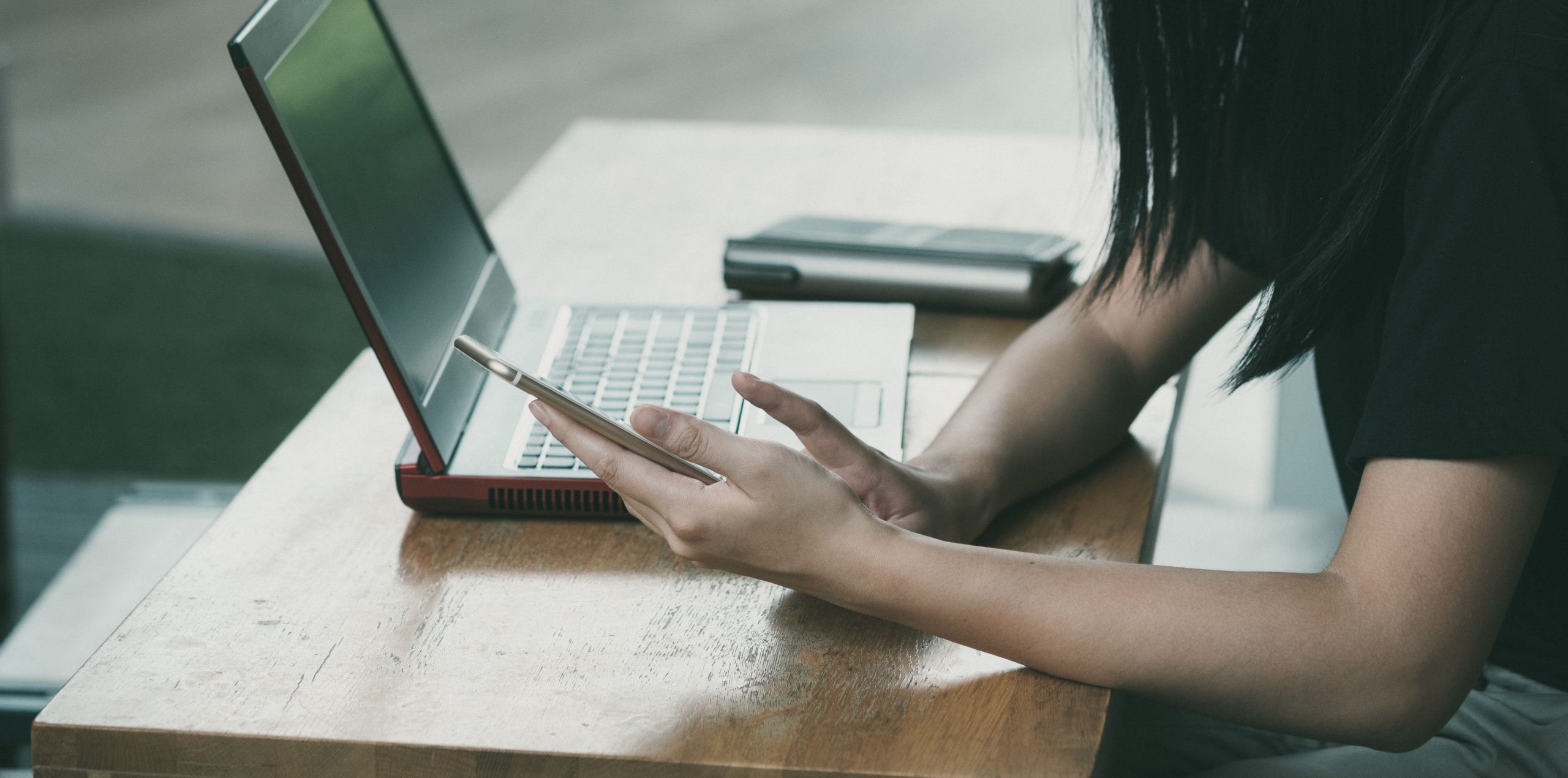 Jeune femme multitachant avec smartphone et laptop