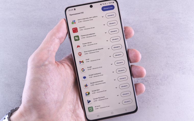Main tenant smartphone affichant mises à jour applications