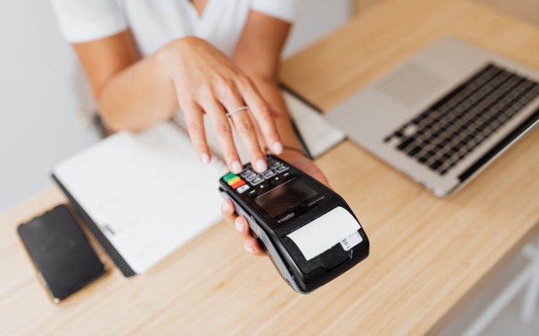 Main utilisant terminal paiement avec laptop