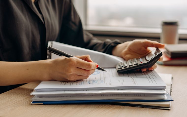 Personne utilisant calculatrice avec documents financiers