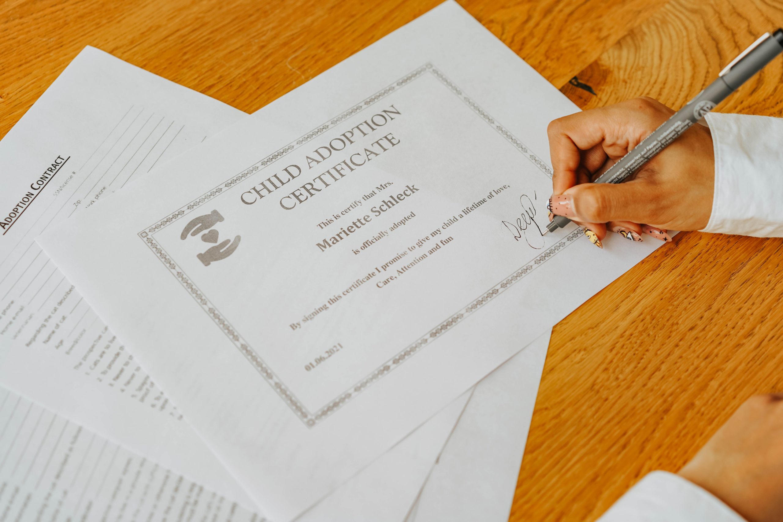 Main signant un certificat d'adoption officiel