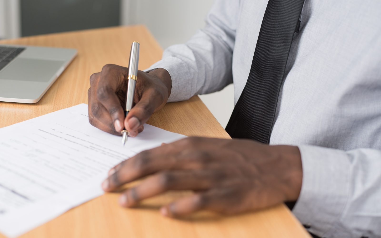 Homme signant des documents sur un bureau professionnel