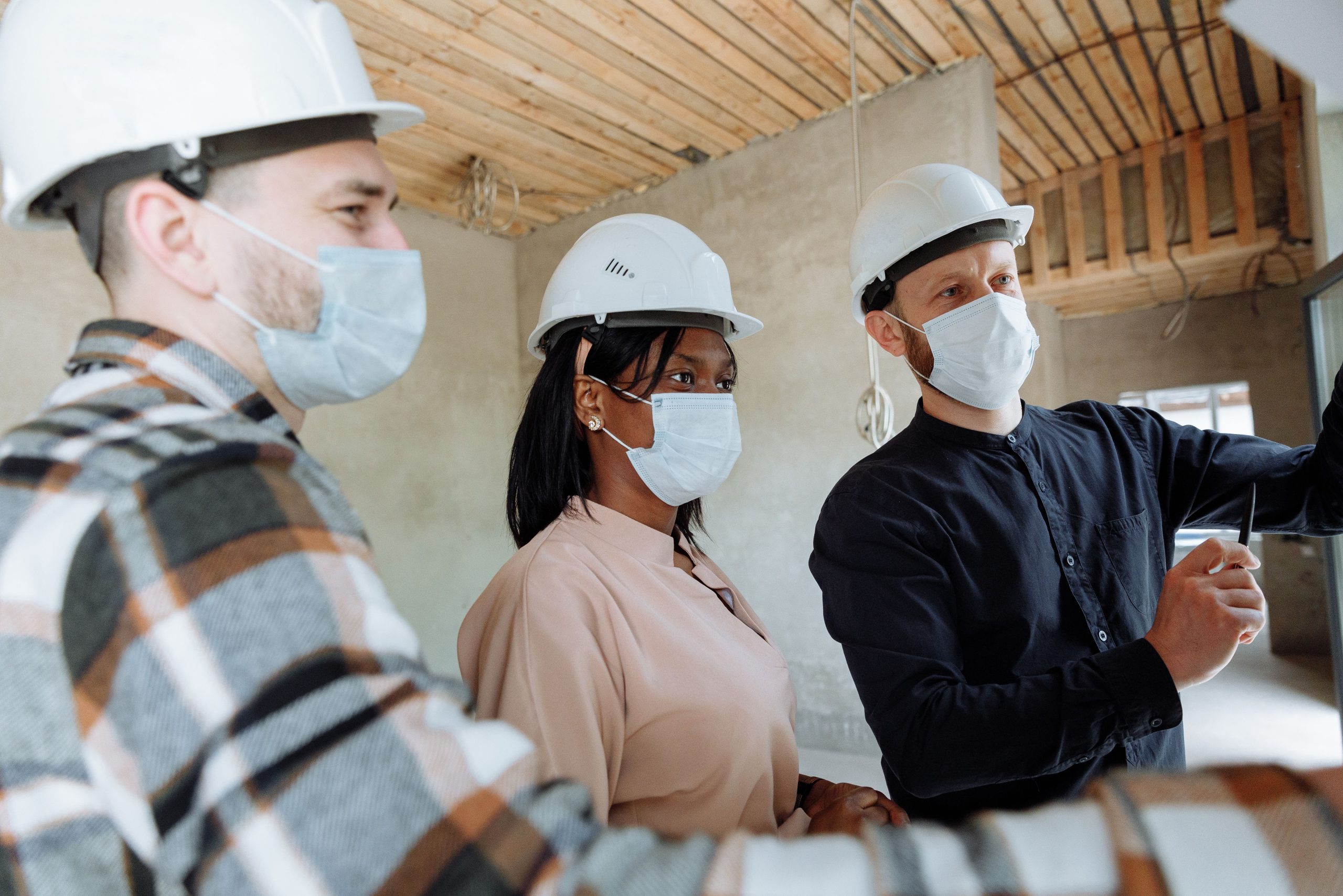 Équipe construction diverse portant masques casques