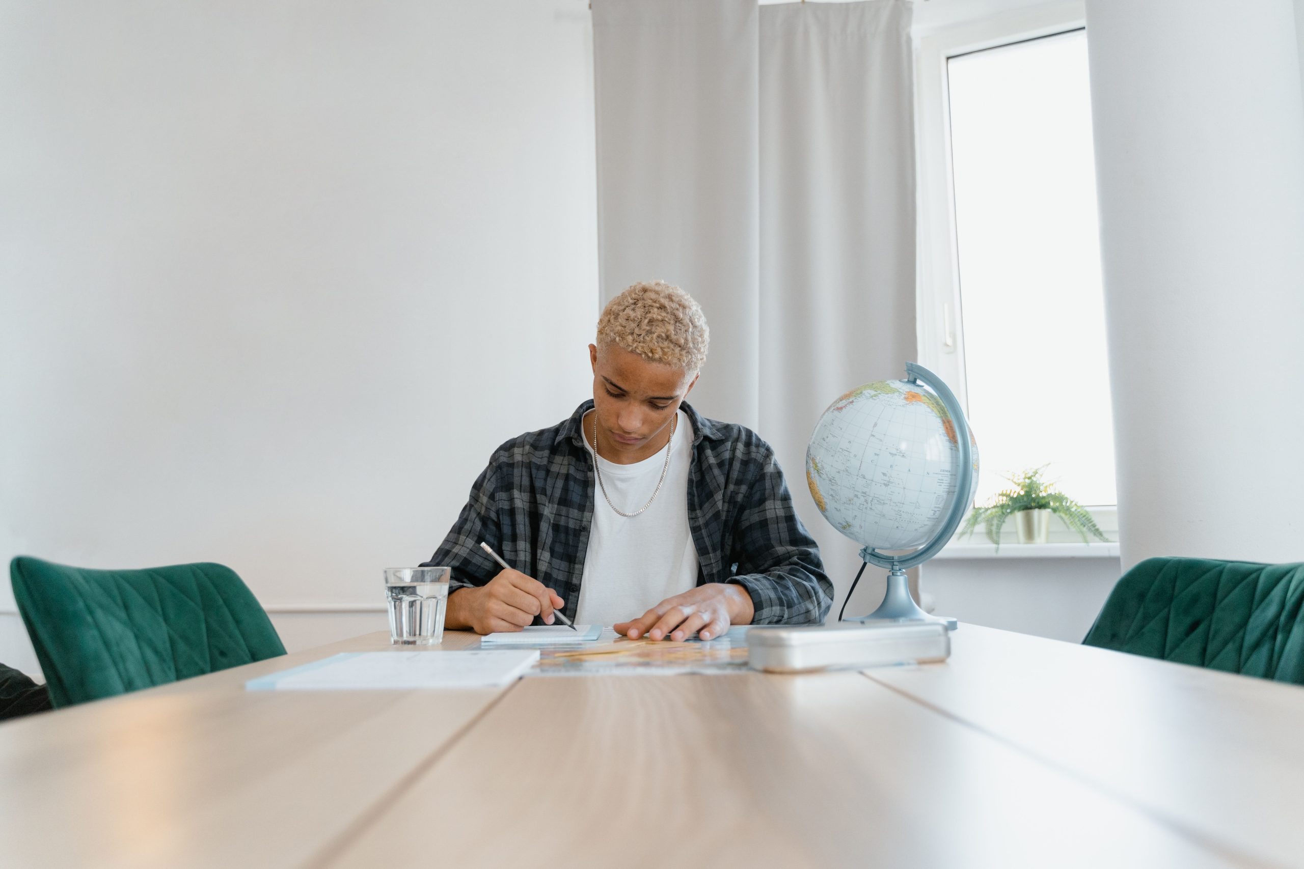 Adolescent étudiant à domicile avec globe monde