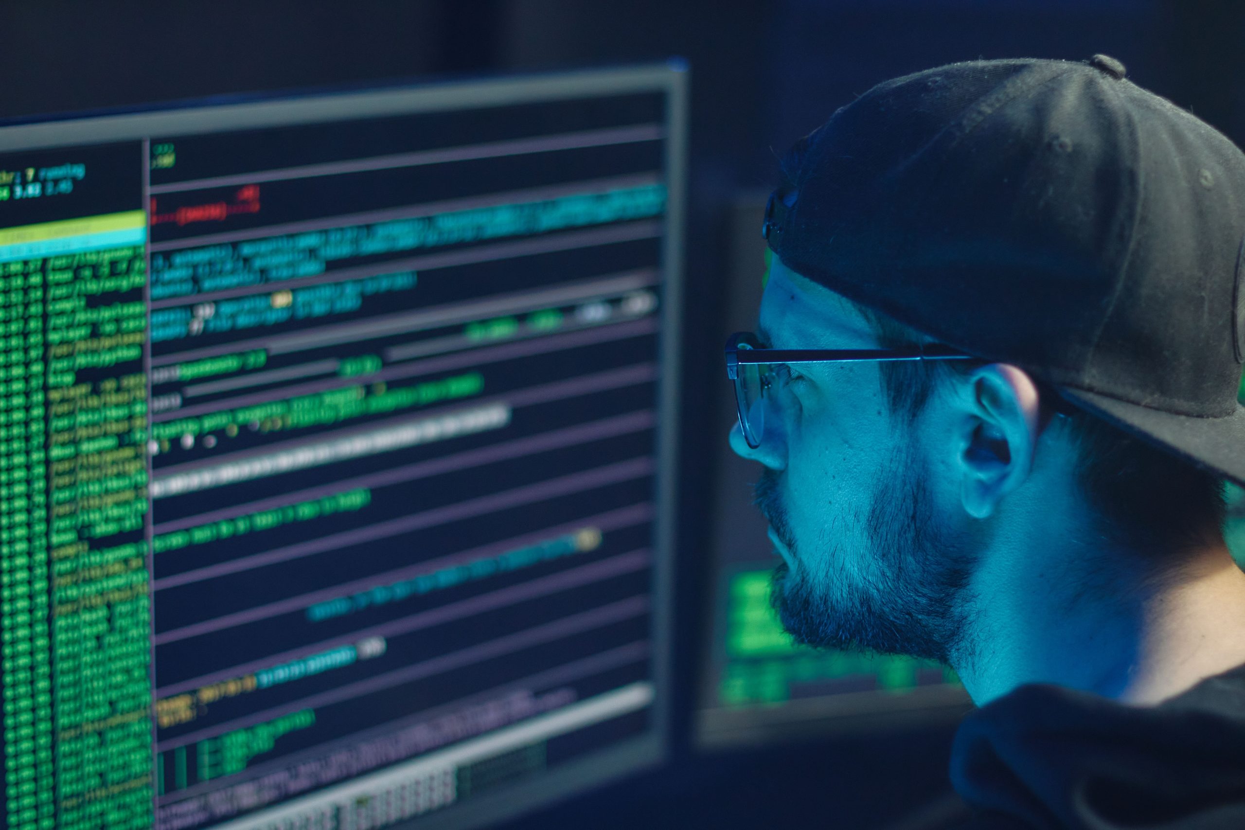 Expert cybersécurité inspectant code sur plusieurs écrans