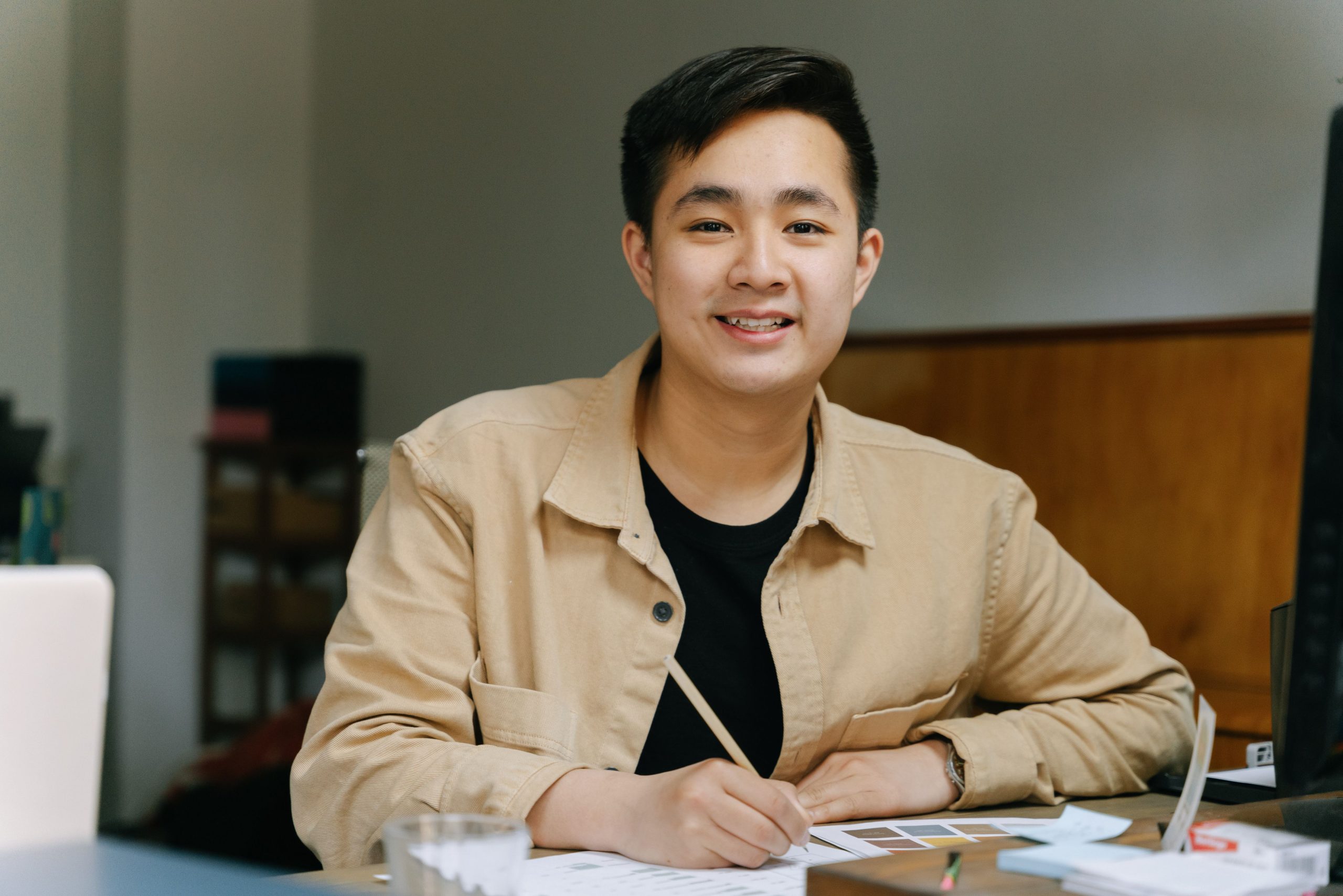 Homme asiatique écrivant souriante à son bureau