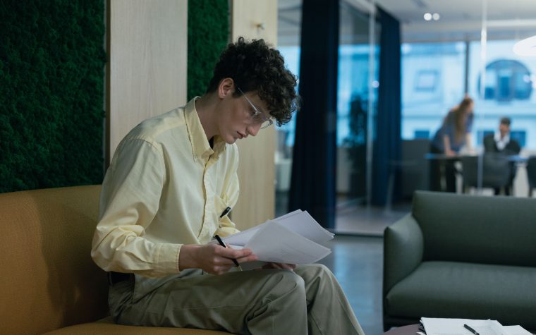 Jeune professionnel lisant des documents sur canapé