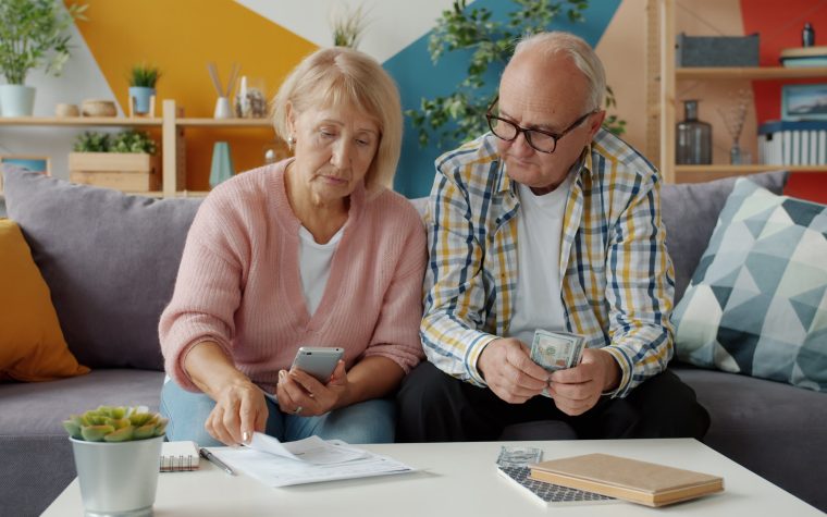 Couple de seniors gérant leurs finances au salon