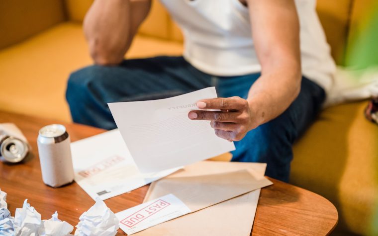 Homme stressé lisant des factures impayées
