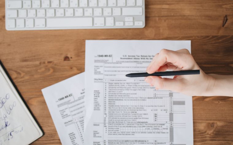 Main tenant un stylo sur formulaire fiscal