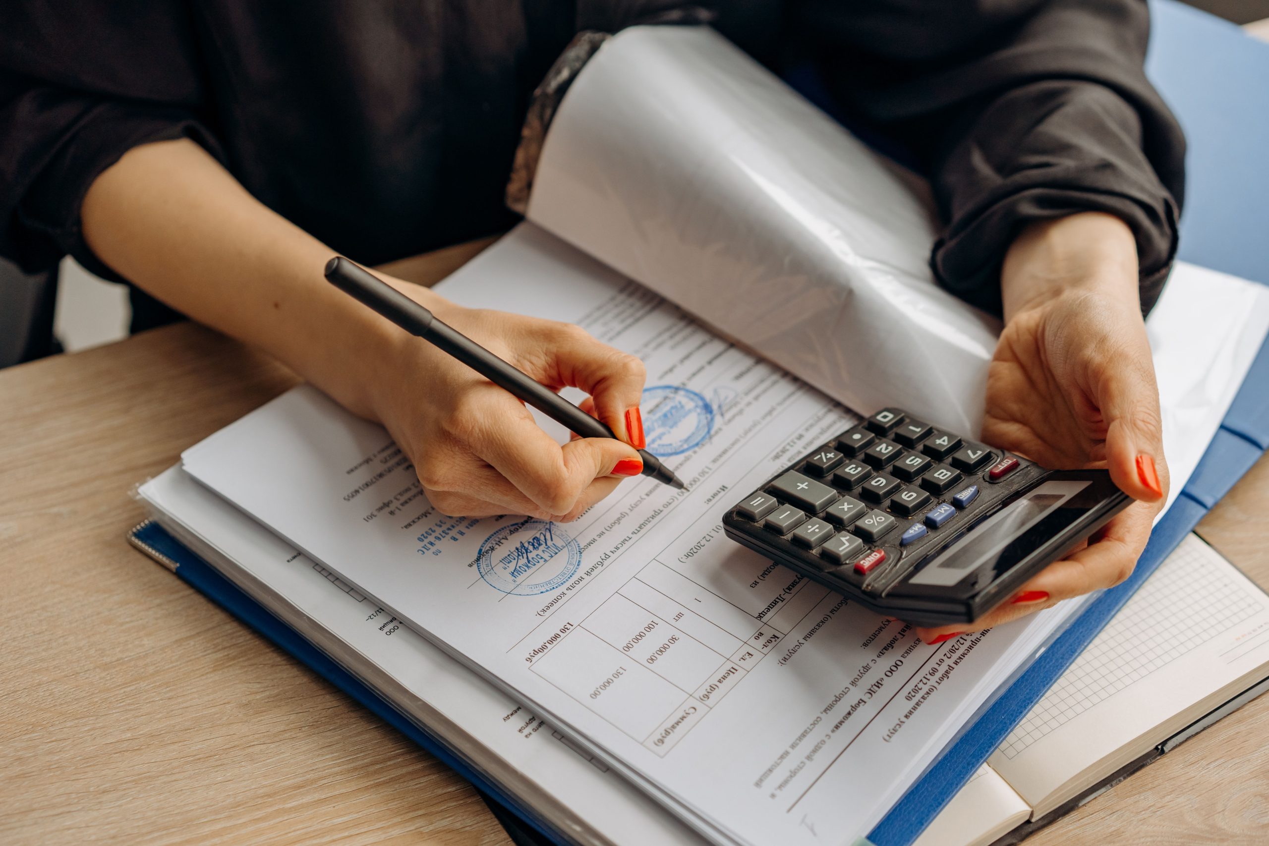 Comptable utilisant une calculatrice et signant des papiers