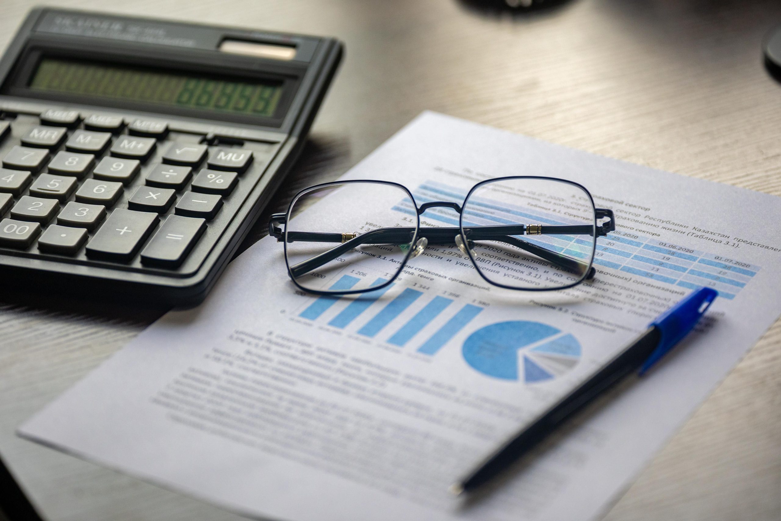 Document financier avec calculatrice et lunettes