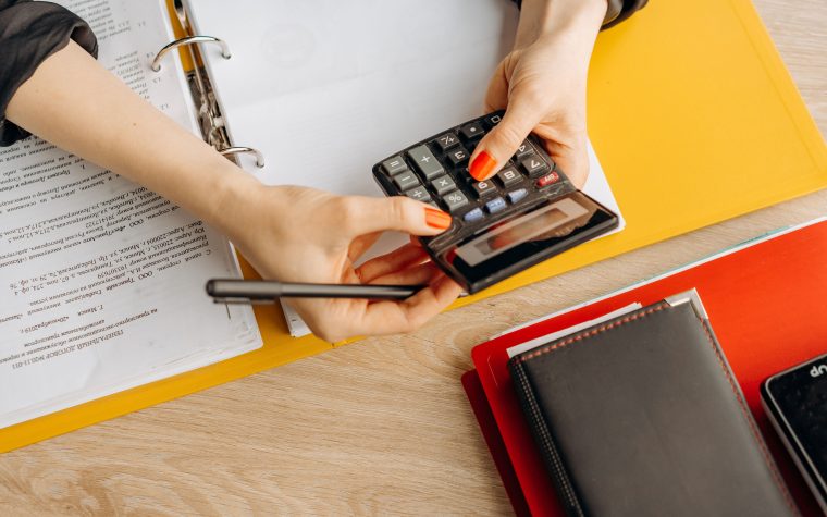 Mains utilisant une calculatrice avec des documents
