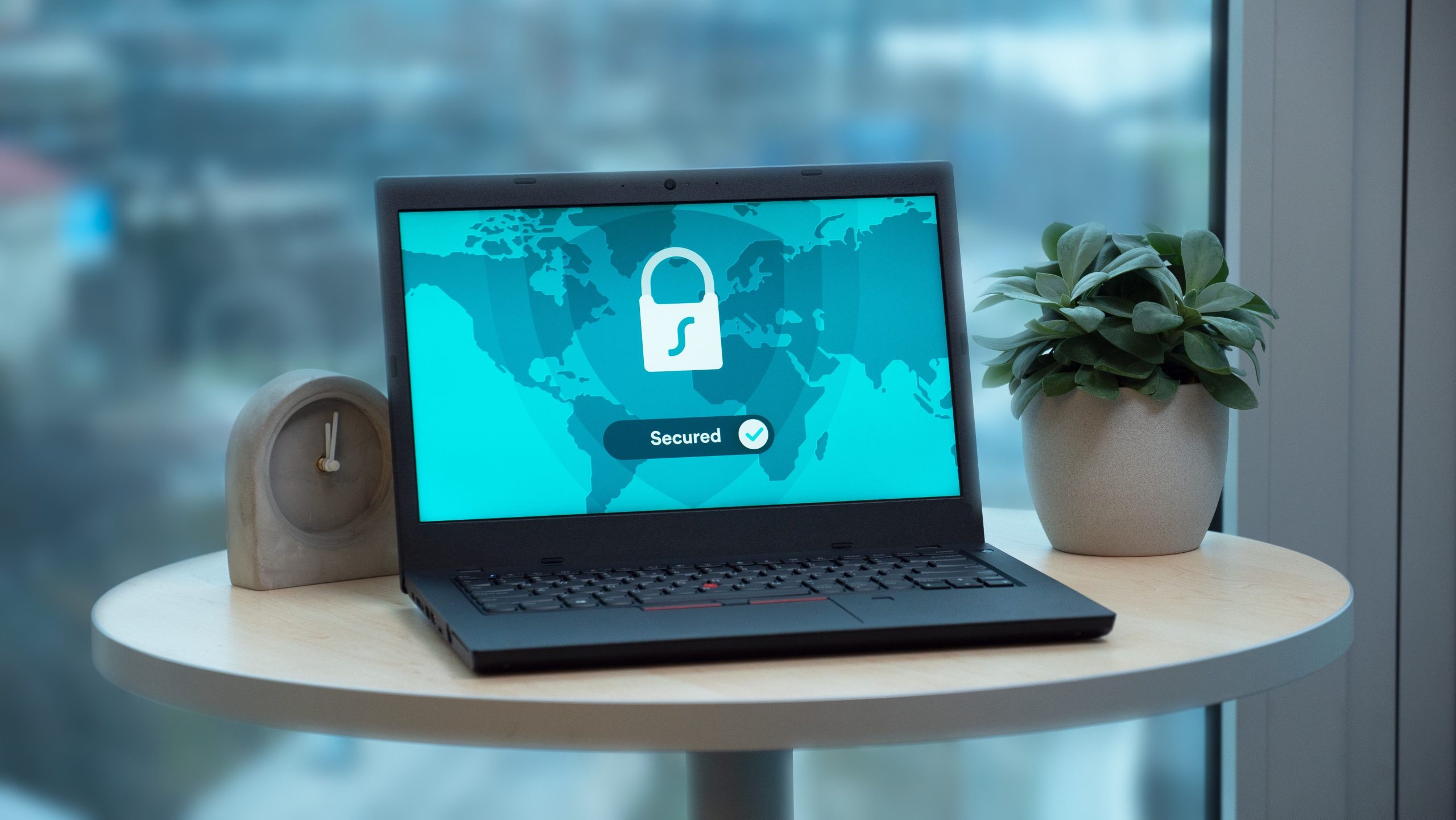 Laptop affichant icône cadenas sécurité avec plante horloge